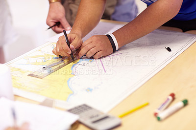 Buy stock photo Cropped shot of an unrecognizable male lifeguard finding co-ordinates on a map in their office