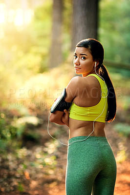 Buy stock photo Fitness, runner and portrait of woman in forest with phone, earphones and confidence in nature. Music, streaming and healthy girl athlete in woods with mobile app, listening and outdoor workout.