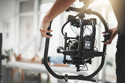 Buy stock photo Behind the scenes shot of an unrecognizable camera operator shooting a scene with a state of the art camera inside of a studio during the day