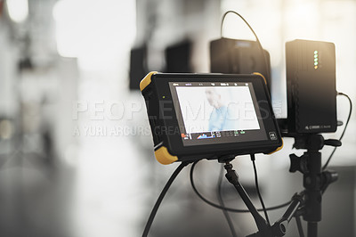 Buy stock photo Behind the scenes shot of videography recording equipment and a screen looking at a scene inside of a studio during the day