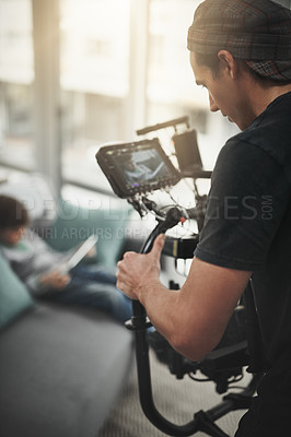 Buy stock photo Behind the scenes shot of a camera operator shooting a scene with a state of the art camera inside of a studio during the day