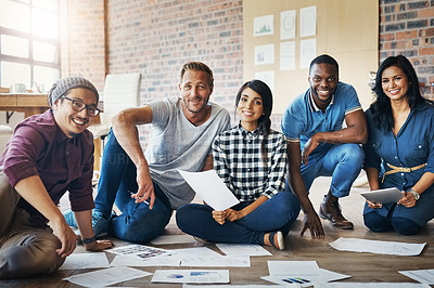 Buy stock photo Portrait of a group of businesspeople brainstorming on the floor in an office