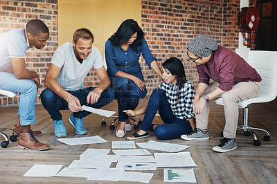Buy stock photo Shot of a group of businesspeople brainstorming on the floor in an office