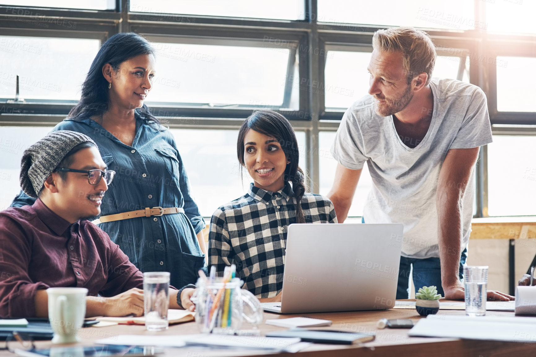 Buy stock photo Shot of a group of businesspeople working together on a laptop in an office