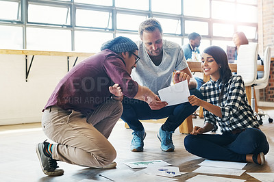 Buy stock photo Shot of a group of businesspeople brainstorming on the floor in an office