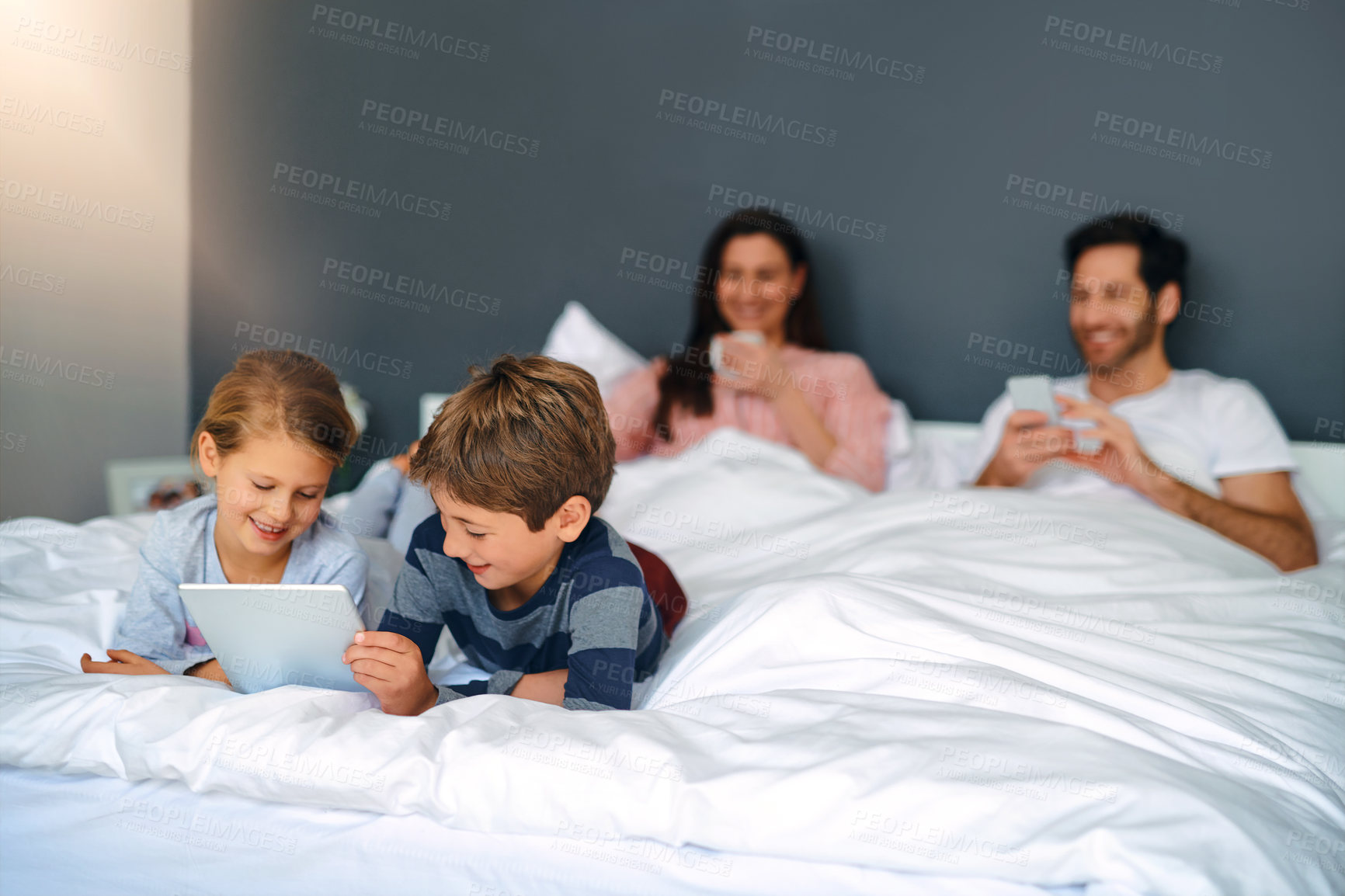 Buy stock photo Kids, tablet and happy on bed in home for education games, watching cartoon or siblings bonding. Children, digital app or smile with parents in bedroom for online video, streaming service and playing