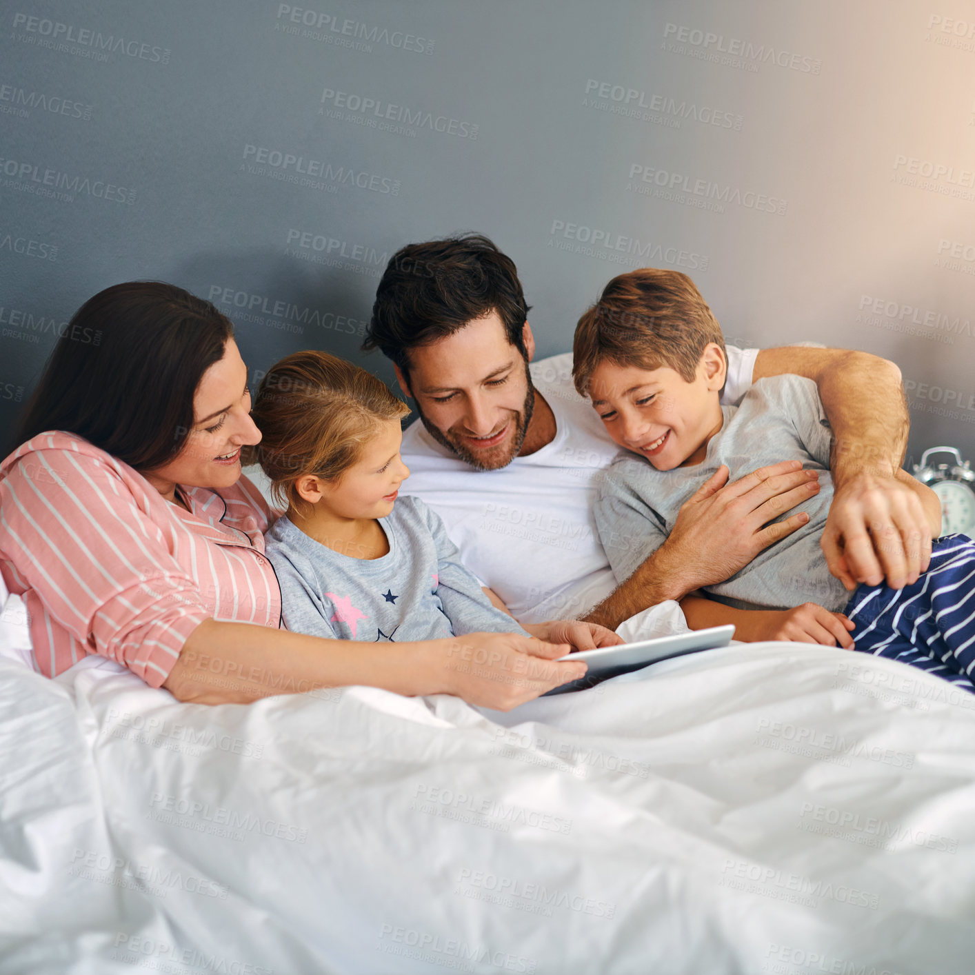 Buy stock photo Parents, children and tablet in home for relax, bonding and playing games together on bed with support. Family, kids and technology in apartment for streaming film, people and movie with development