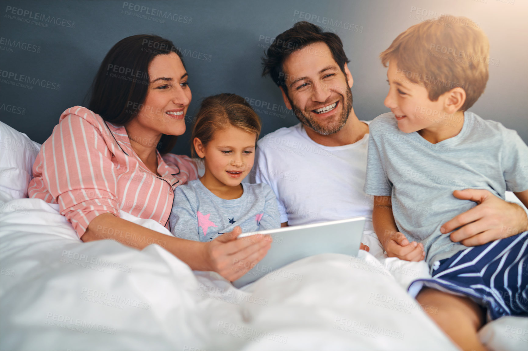 Buy stock photo Family, happy and tablet in home for relax, internet and playing game together in bed with support. Parents, kids and technology in apartment for streaming film, bonding and movie with development