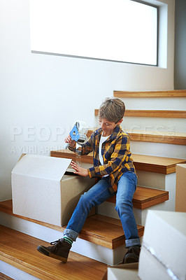 Buy stock photo Shot of an adorable little boy packing boxes on moving day