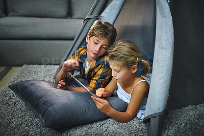 Buy stock photo Children, playing and tablet in home for relax, bonding and game together in tent with cartoon. Family, siblings and happy in lounge for streaming film, people and development with social media app