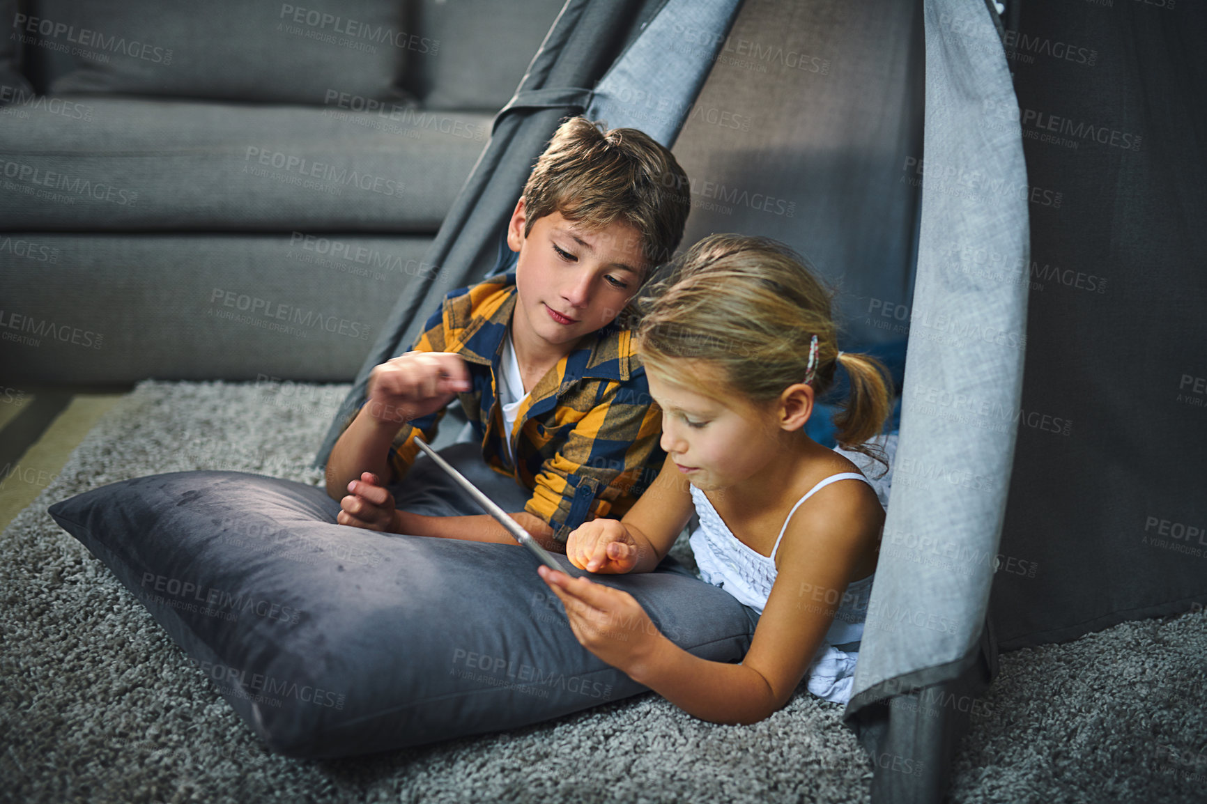 Buy stock photo Children, playing and tablet in home for relax, bonding and game together in tent with cartoon. Family, siblings and happy in lounge for streaming film, people and development with social media app