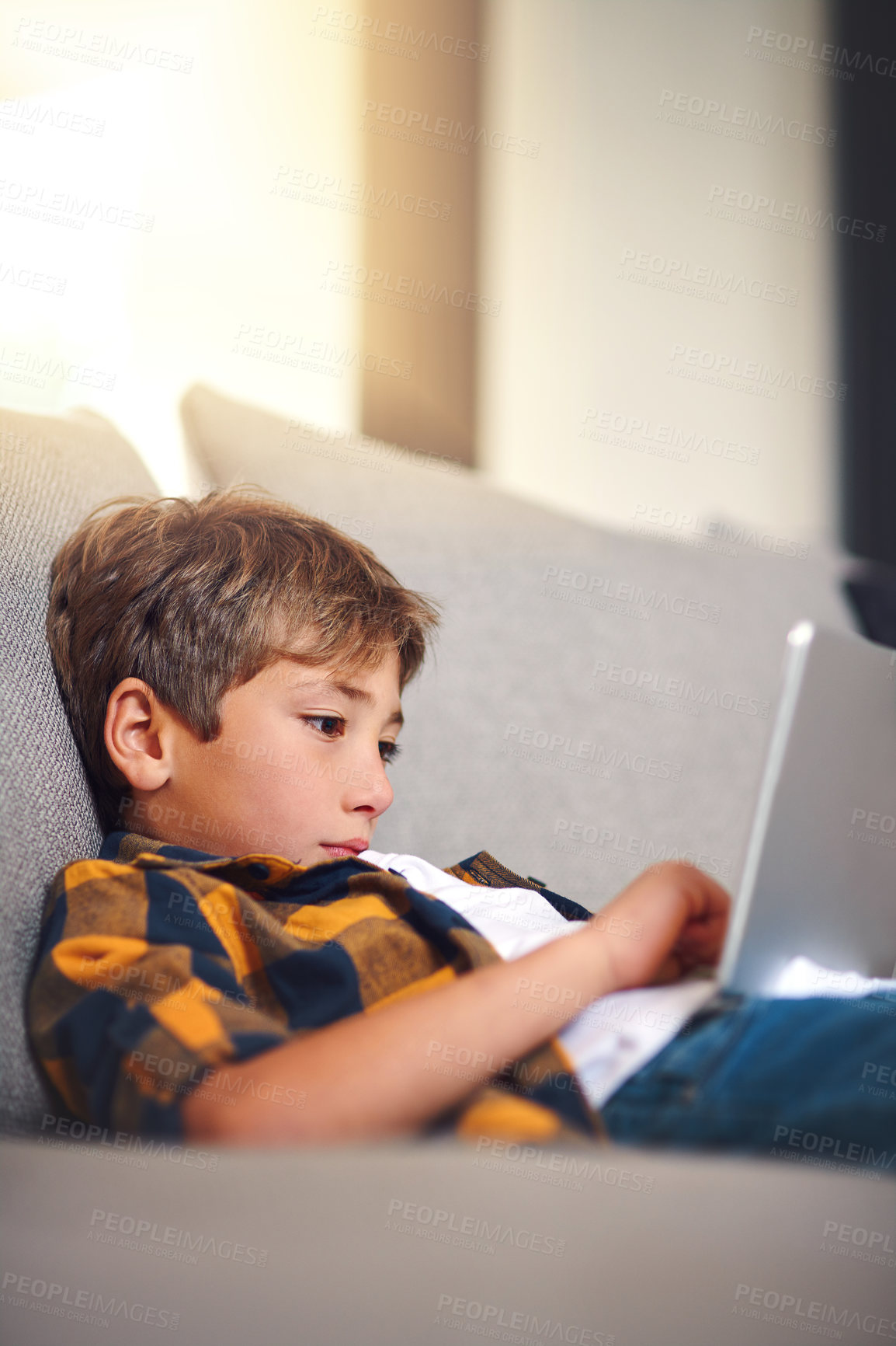 Buy stock photo Home, sofa and boy child with tablet, online game and search for video streaming on website. Scroll, relax and kid on couch with digital app for elearning, internet connection or technology in lounge