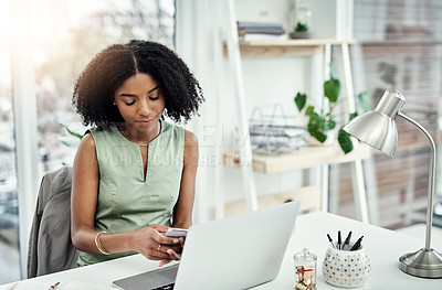Buy stock photo Cropped shot of an attractive young businesswoman sending a text message while working at her desk in the office