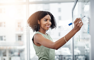 Buy stock photo Cropped shot of an attractive young businesswoman working on a glass wipe board in her office