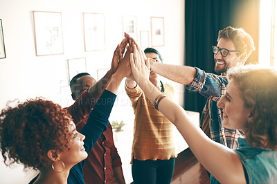 Buy stock photo Shot of a group of designers high fiving together in an office