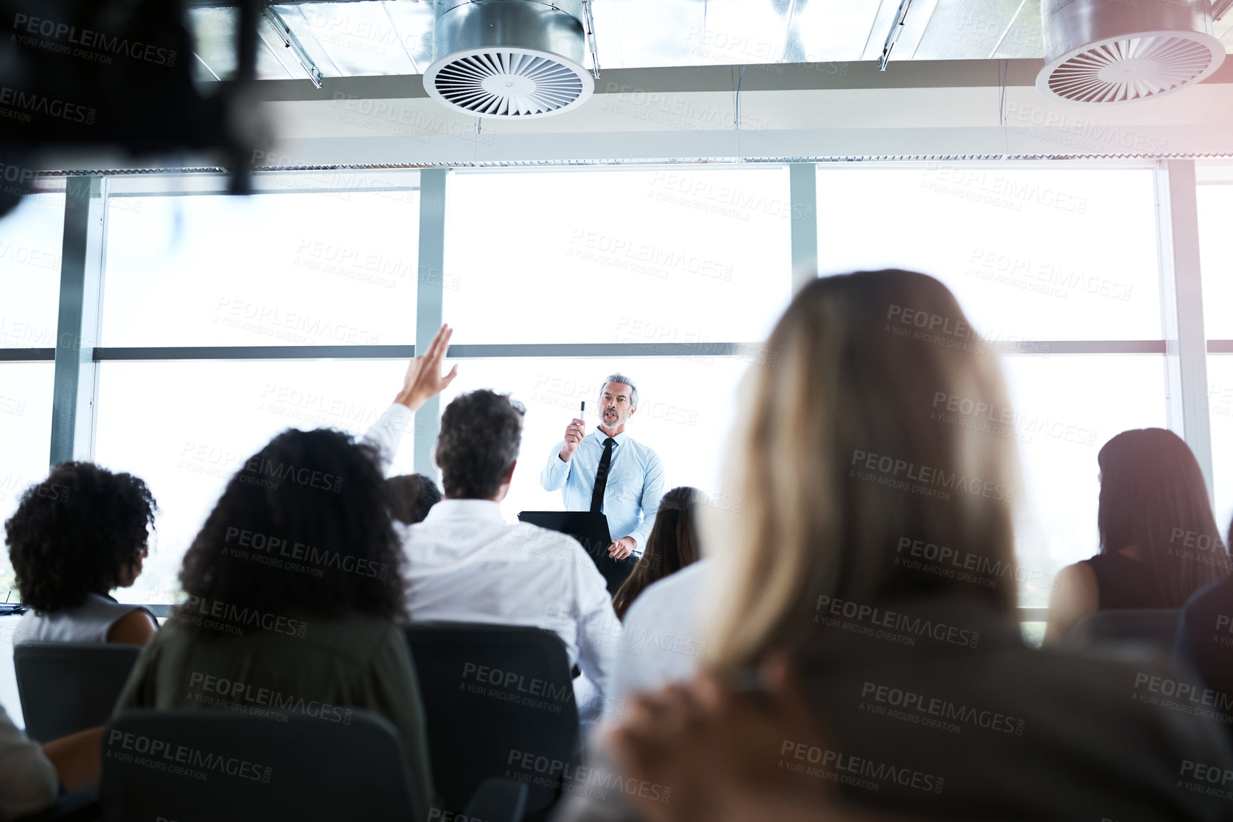 Buy stock photo Shot of a group of businesspeople raising their hands during a presentation