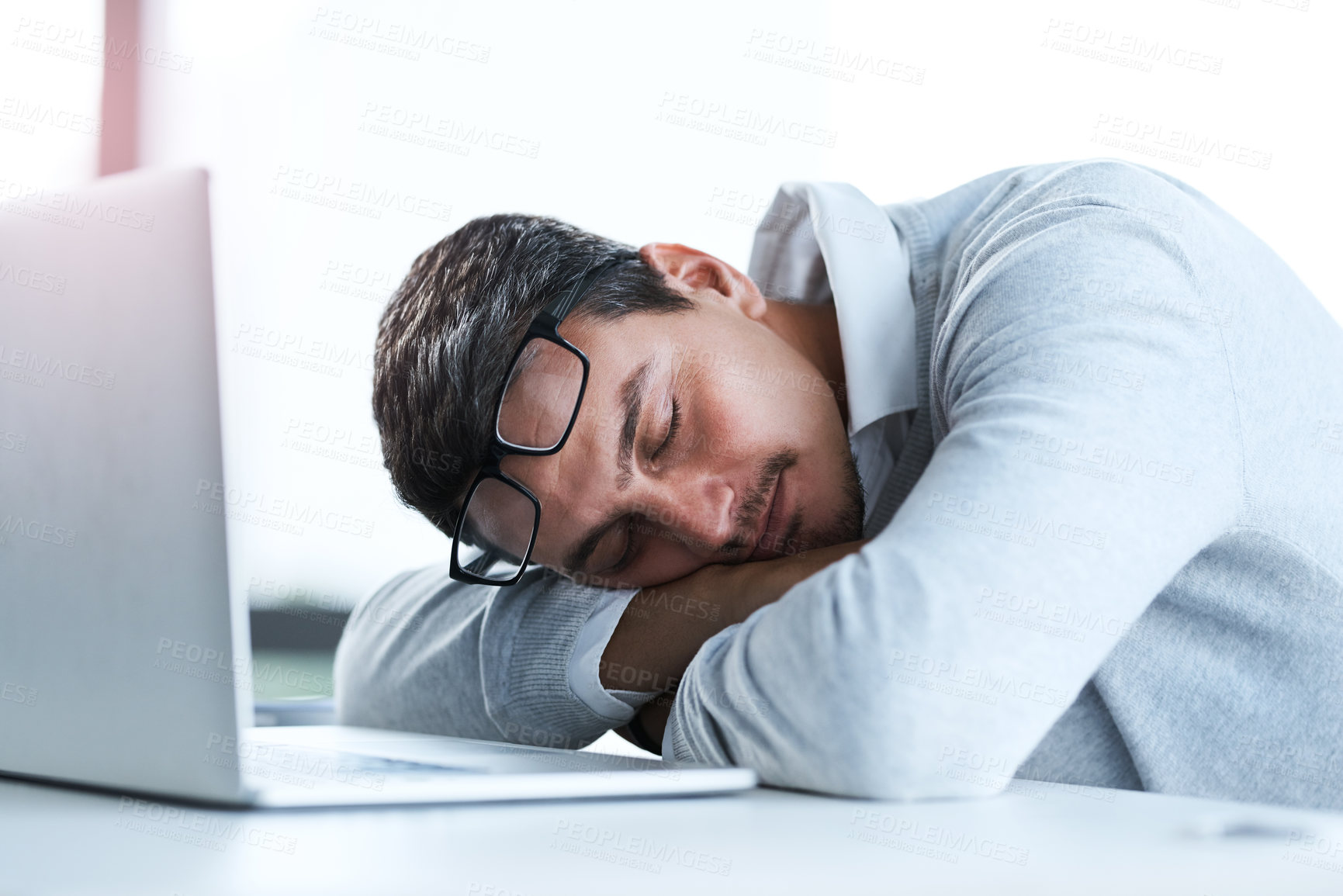 Buy stock photo Tired businessman, sleeping and rest with laptop on desk for lazy day, done or finished at office. Young, man or employee asleep on table with computer for fatigue, burnout or dreaming at workplace