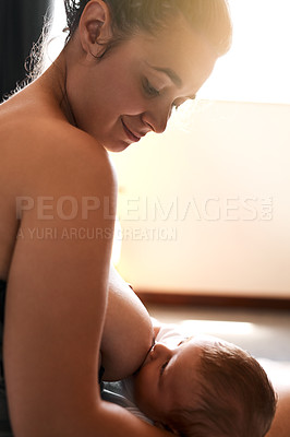 Buy stock photo High angle shot of a young mother breastfeeding her newborn baby at home