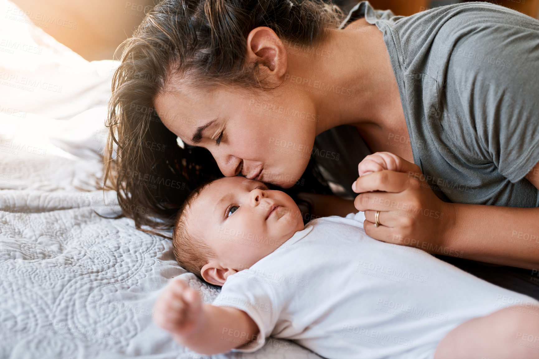 Buy stock photo Mother, baby and forehead kiss on bed in home for support, love and care for growth and child development. Parent, kid and happy in bedroom with trust for bonding, childhood memories and toddler