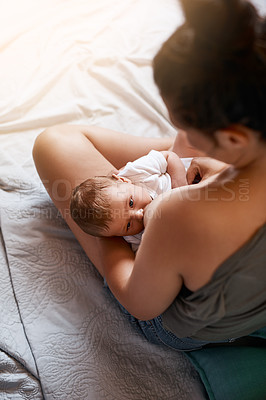 Buy stock photo Mom, baby and breastfeeding on bed in bedroom for growth development, nutrition or digestive health. Lens flare, top view and woman with newborn child for natural milk, wellness or bonding in home