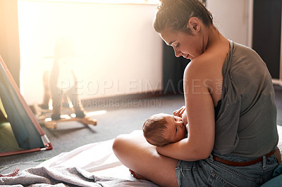 Buy stock photo High angle shot of a young mother breastfeeding her newborn baby at home