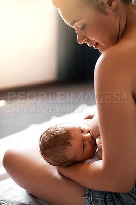 Buy stock photo High angle shot of a young mother breastfeeding her newborn baby at home