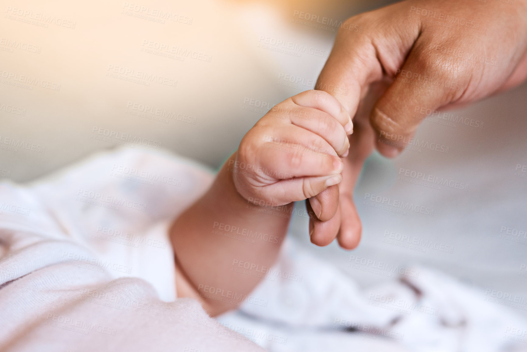 Buy stock photo Newborn, hands and holding fingers with person in house, wellness and affection together for family bonding with baby. Bedroom, parent and relax with infant for care, childhood and growth with love