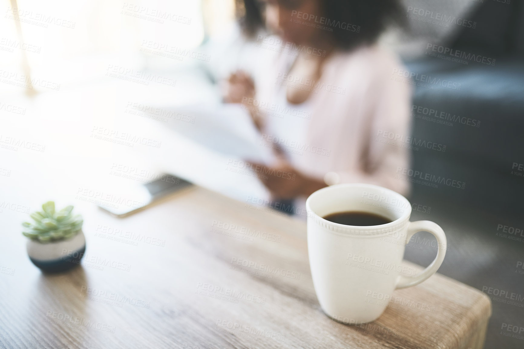 Buy stock photo Cup, coffee and woman in house, morning and break with comfort, caffeine and resting. Apartment, blur and person with mug, espresso and lens flare with wooden table, energy and relaxing in lounge