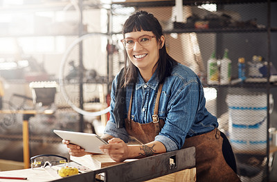Buy stock photo Cropped portrait of an attractive young woman working on her laptop while standing in her creative workshop
