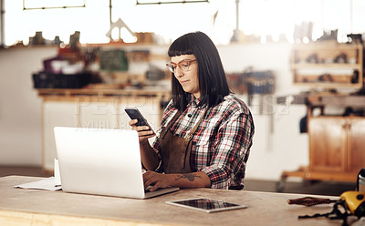 Buy stock photo Cropped shot of an attractive young woman working on her laptop while sitting in her creative workshop