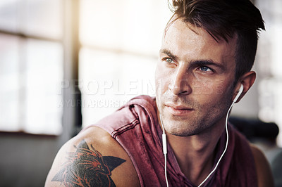 Buy stock photo Man, tired and music in gym for workout, exercise and wellness with radio for motivation. Training, thinking and male bodybuilder on break from cardio, fitness and earphones for listening to podcast