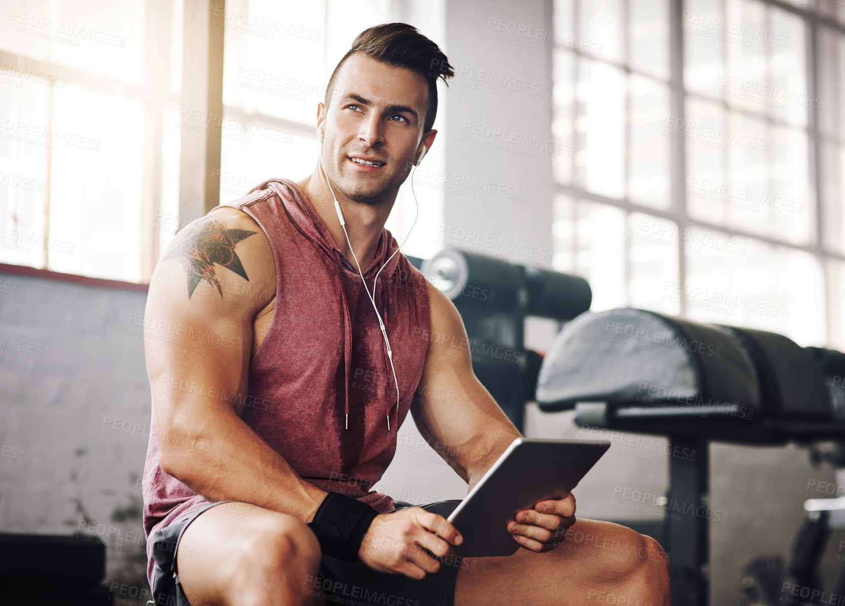 Buy stock photo Cropped shot of a handsome young man using a tablet at the gym