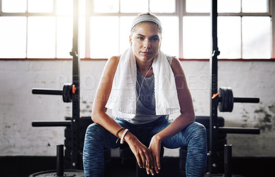 Buy stock photo Cropped shot of an attractive young woman taking a break during her workout at the gym