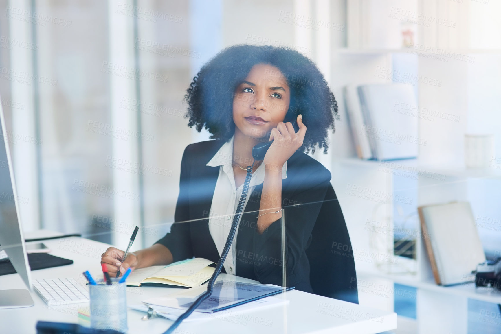 Buy stock photo Shot of a young businesswoman talking on a telephone in an office