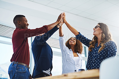 Buy stock photo Cropped shot of a group of creative employees high fiving while celebrating in a modern office