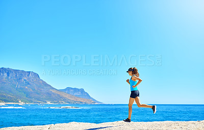 Buy stock photo Shot of a young woman our running on the beach on a sunny day