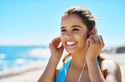 Buy stock photo Shot of a sporty young woman listening to music while out for her workout