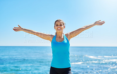 Buy stock photo Shot of a sporty young woman standing with her arms outstretched
