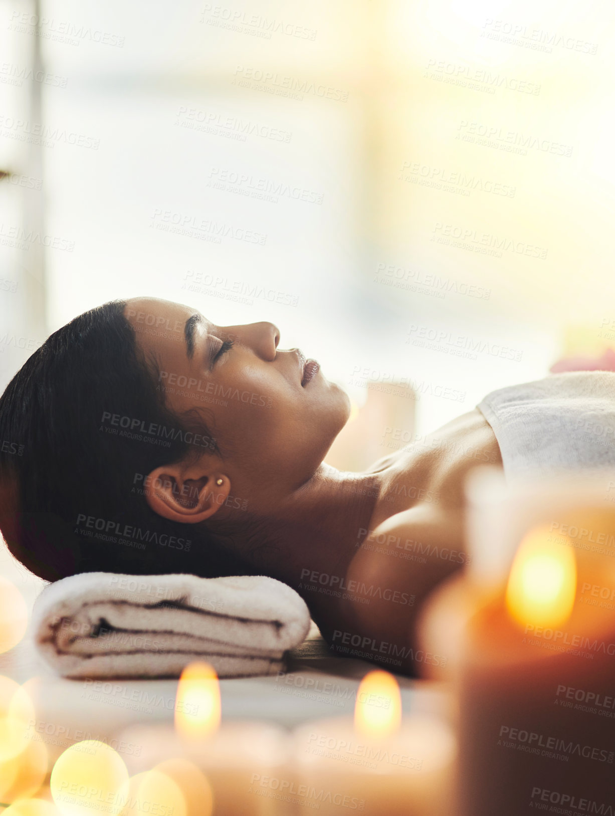 Buy stock photo Shot of an attractive young woman relaxing on a massage table at a spa