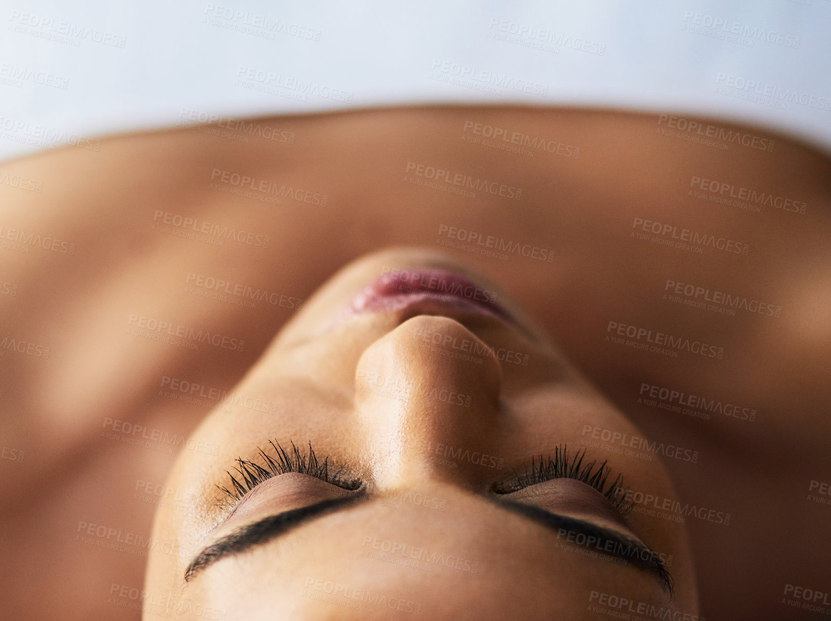 Buy stock photo Shot of an attractive young woman relaxing on a massage table at a spa