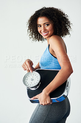 Buy stock photo Studio shot of an athletic young woman holding a scale against a grey background