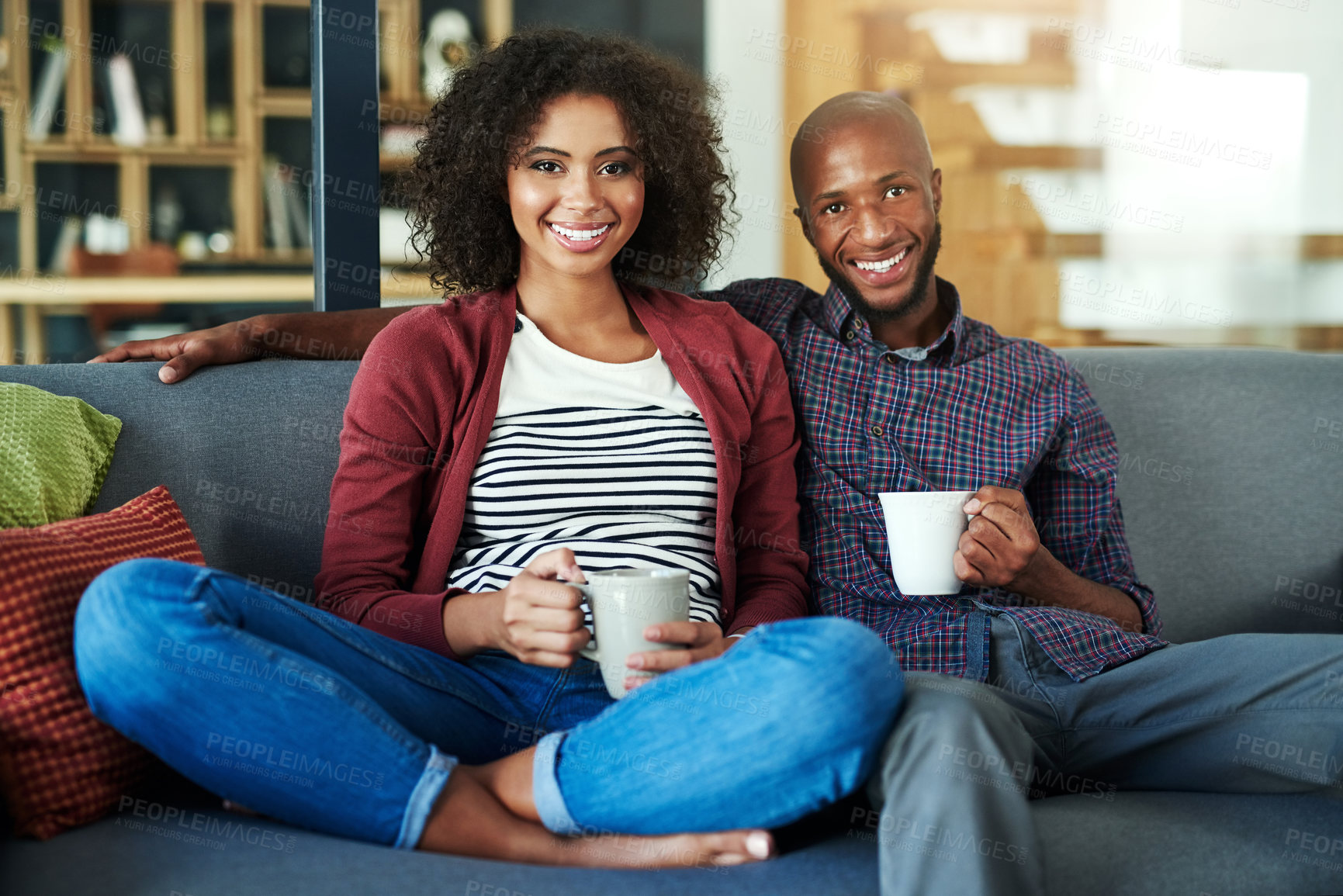 Buy stock photo Portrait of a happy young couple enjoying a relaxing coffee break together on the sofa at home