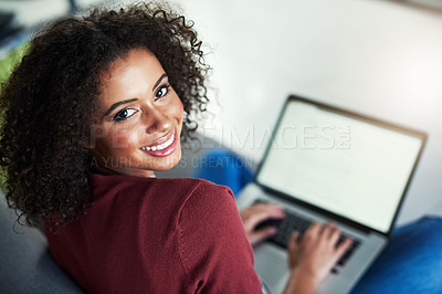 Buy stock photo Portrait of a young woman using a laptop while relaxing on the sofa at home