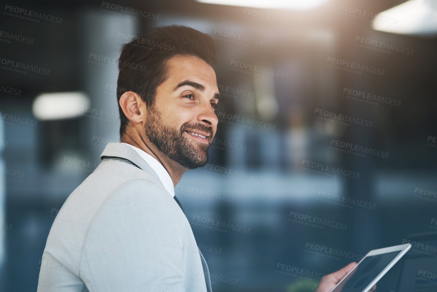 Buy stock photo Shot of a young businessman working on a digital tablet in an office