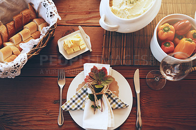 Buy stock photo Above, lunch celebration and food on table for holiday, Sunday dinner or party. Table setting, nutrition and feast at a dining room table for a dinner party, fine dining and foods at a place setting