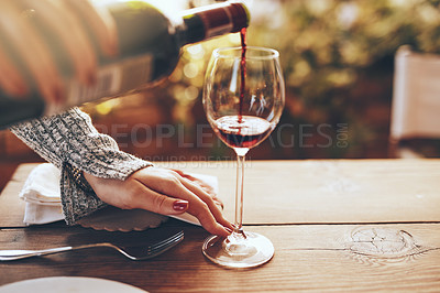 Buy stock photo Hands, pouring wine and at dinner party for celebration, relax and enjoy beverage. Woman, glass and red alcohol for dining table, for lunch and brunch for holiday, on break and calm in summer event.