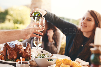 Buy stock photo Party, dinner and woman pouring wine in a wine glass to cheers at an outdoor celebration feast. Champagne, toast and girl serving a luxury alcohol drink at event in nature or backyard garden at home.
