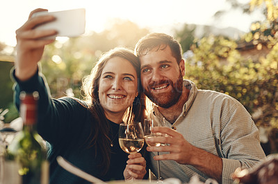 Buy stock photo Wine, phone and couple take a selfie with a toast to a happy marriage and share romantic content on social media. Woman smiles taking pictures on a date with a lovely partner drinking champagne 