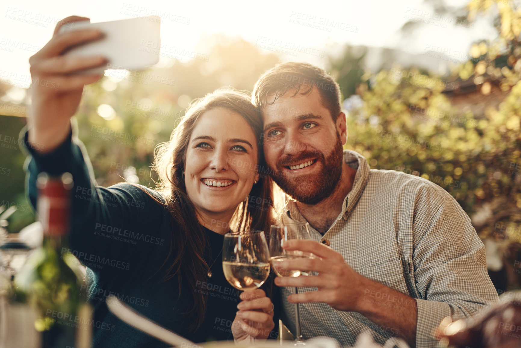 Buy stock photo Wine, phone and couple take a selfie with a toast to a happy marriage and share romantic content on social media. Woman smiles taking pictures on a date with a lovely partner drinking champagne 