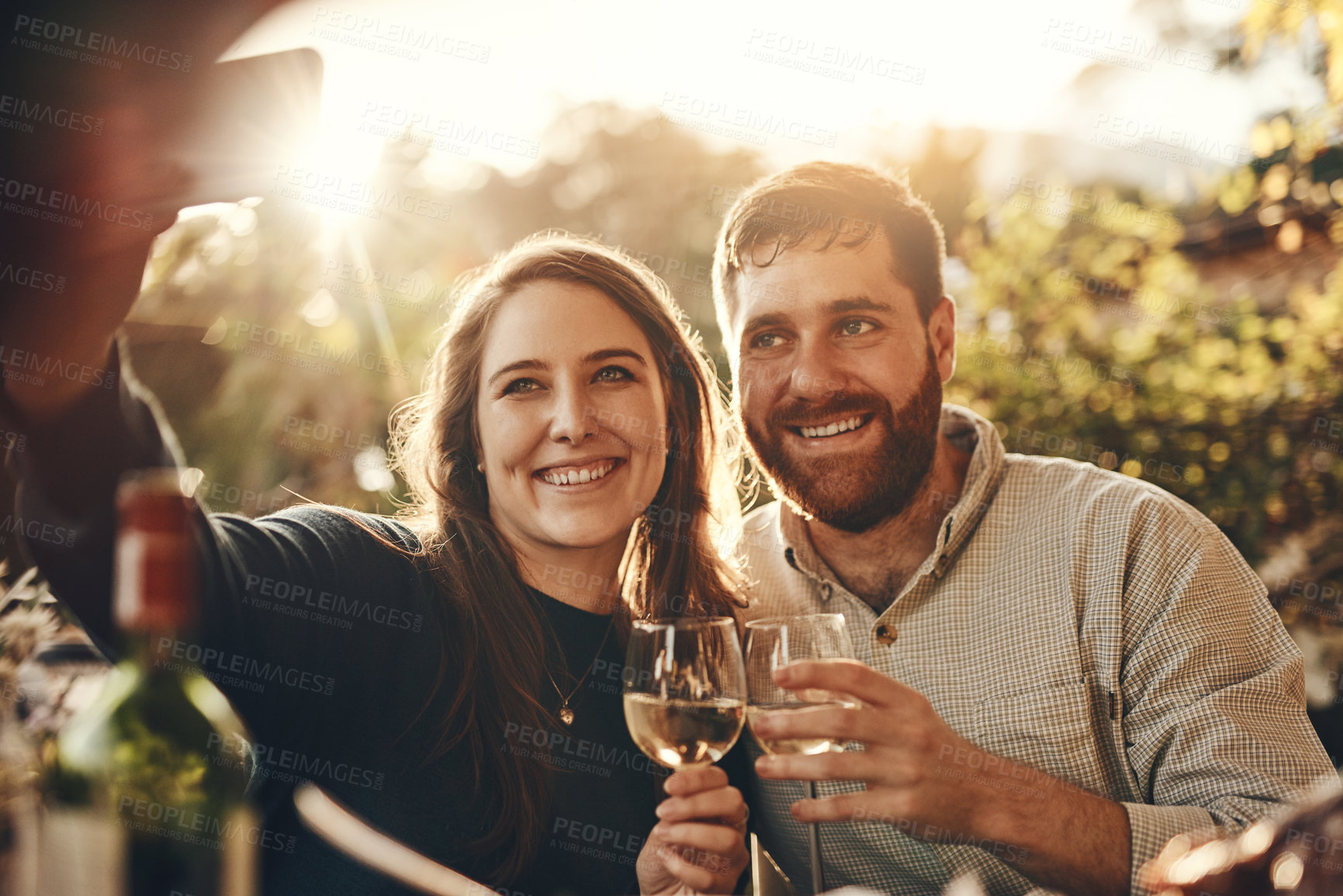 Buy stock photo Phone selfie, wine toast and couple on romantic love date for marriage anniversary, outdoor freedom or peace. Picture flare, fine dining and wine tasting man and woman bonding at vineyard restaurant